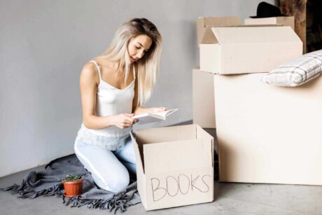 Front view woman packing books scaled